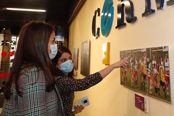 Mercedes Pérez de Prada, técnica del área de género del CERMI, explica a la Reina la exposición de fotos