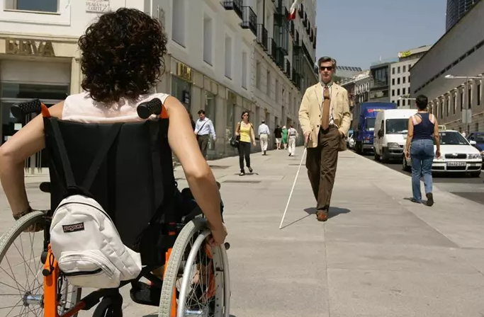 Imagen de una mujer en silla de ruedas y un hombre ciego que usa bastón.