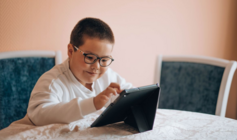 Imagen de un niño con discapacidad que lee en una tableta digital