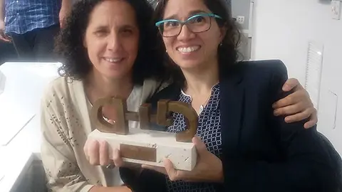 Catalina Devandas y Ana Peláez cogiendo juntas el premio CERMI otorgado a la Relatora de Naciones Unidas