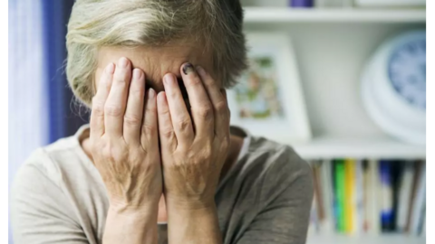 Imagen de una mujer mayor cubriéndose el rostro con las manos
