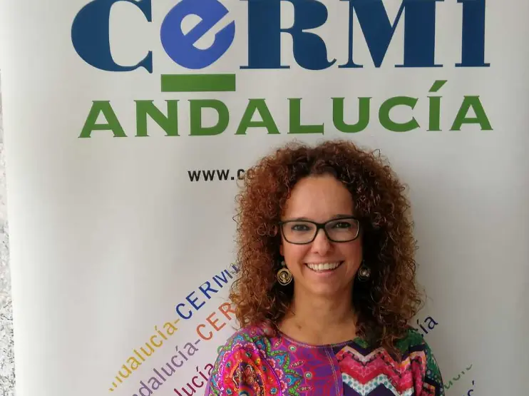Imagen de Marta Castillo, detrás tiene el logotipo de CERMI Andalucía.