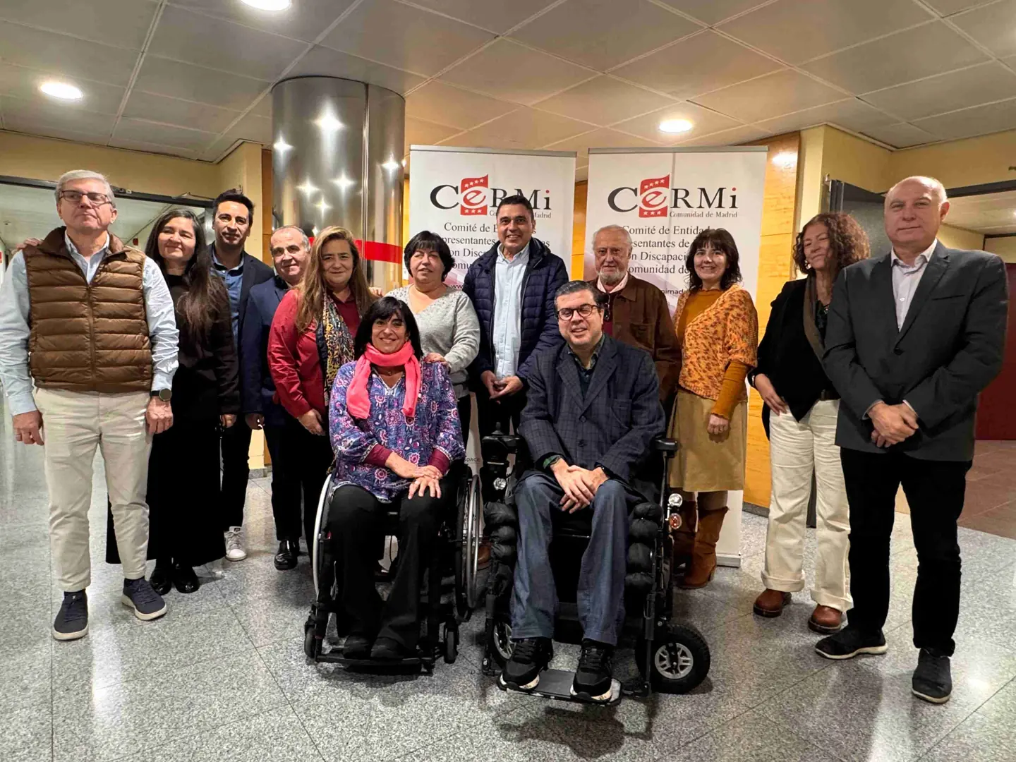 Imagen de la nueva presidenta del CERMI Madrid, Mayte Gallego, rodeada de personas miembro de la entidad tras su elección.